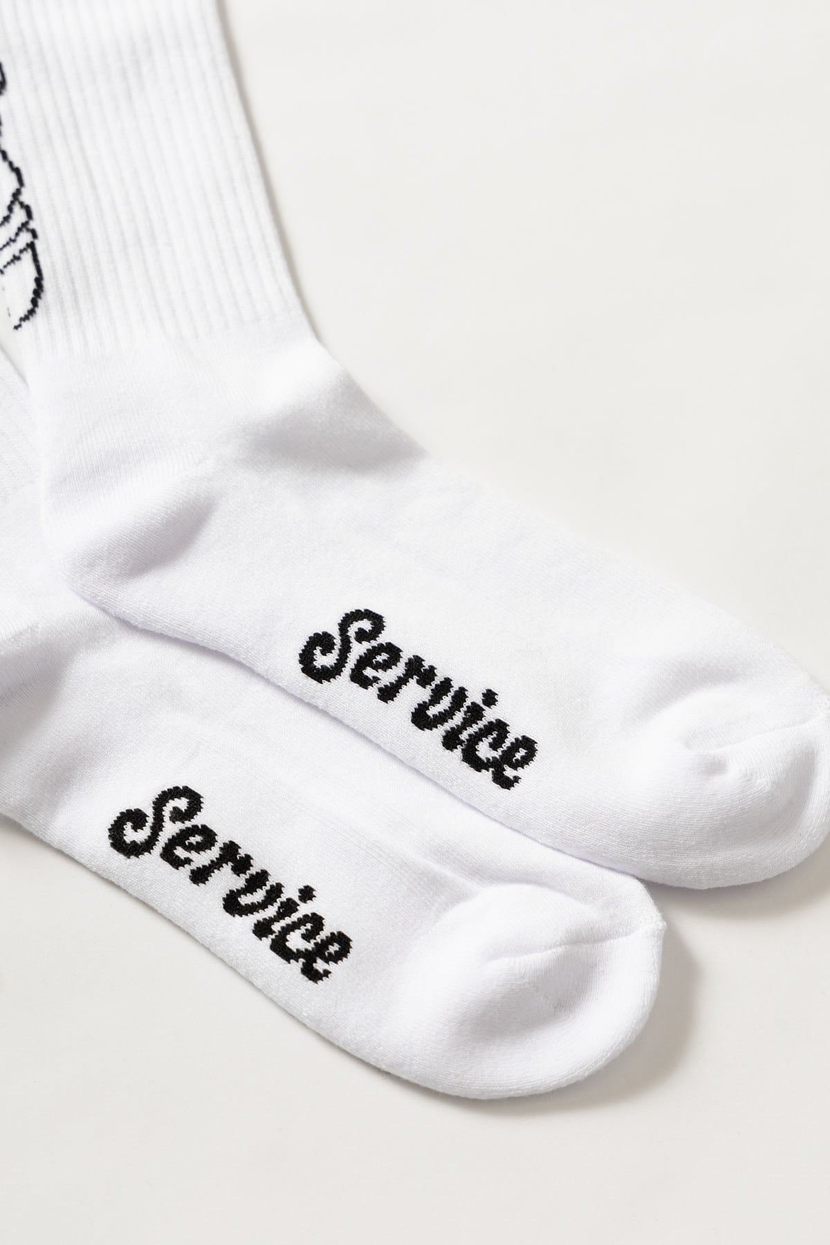 White crew socks with salt and pepper graphic on the back, showing rear design detail and fit