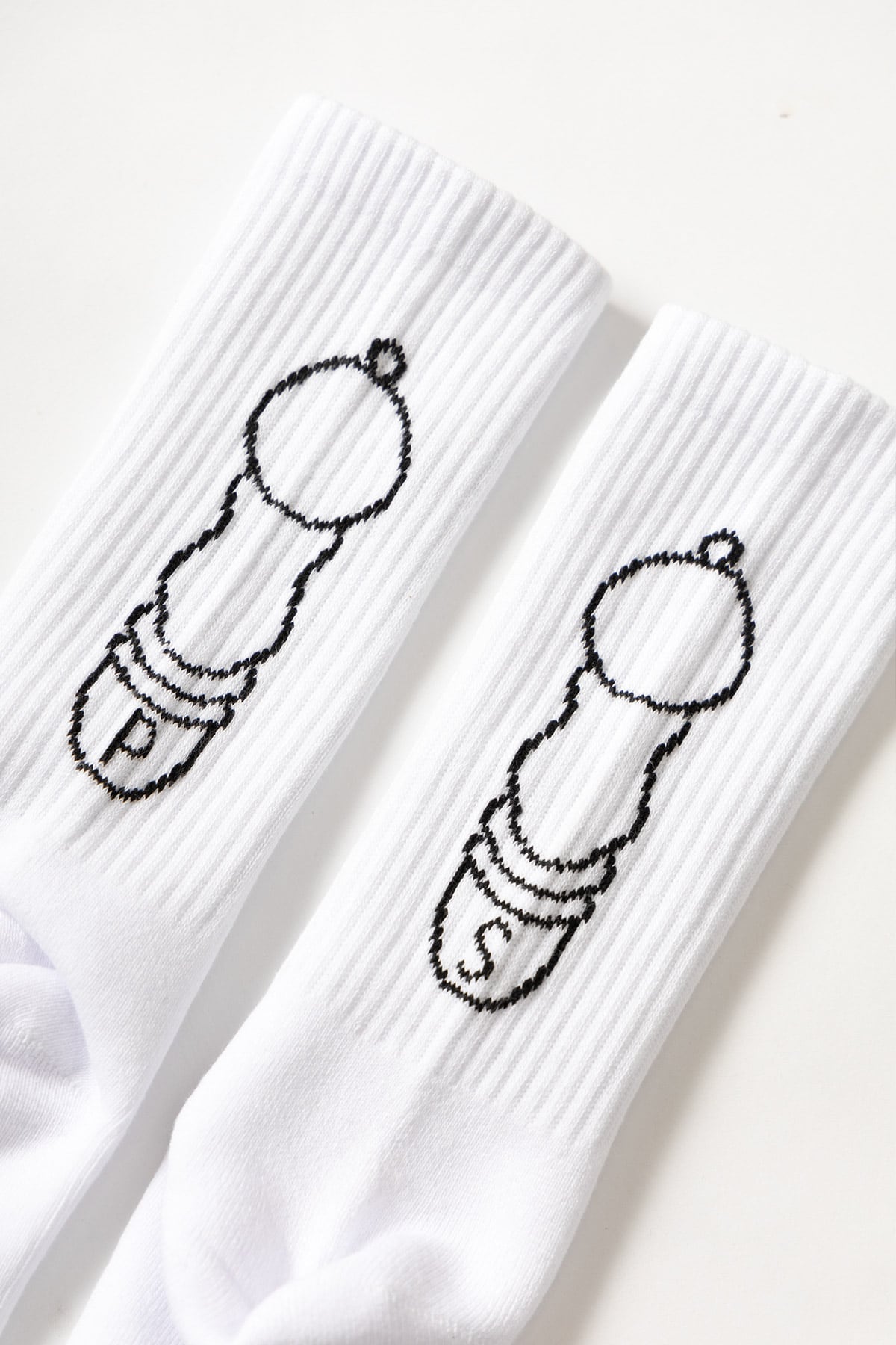 Close-up of white crew socks with salt and pepper graphic showing fabric texture and stitching detail