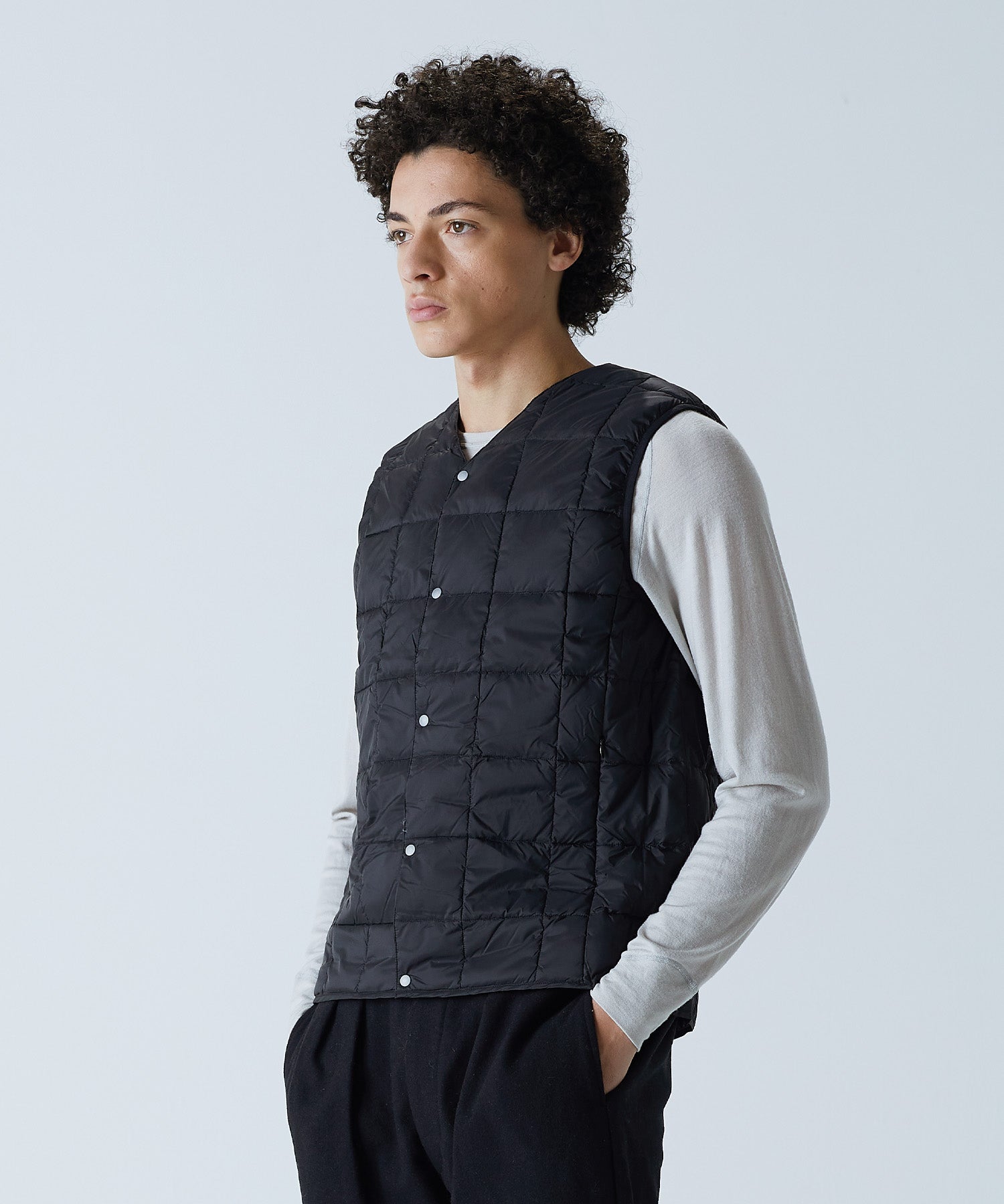 Model wearing TAION Men's V-Neck Button Down Down Vest in Black with 800 Fill Power insulation
