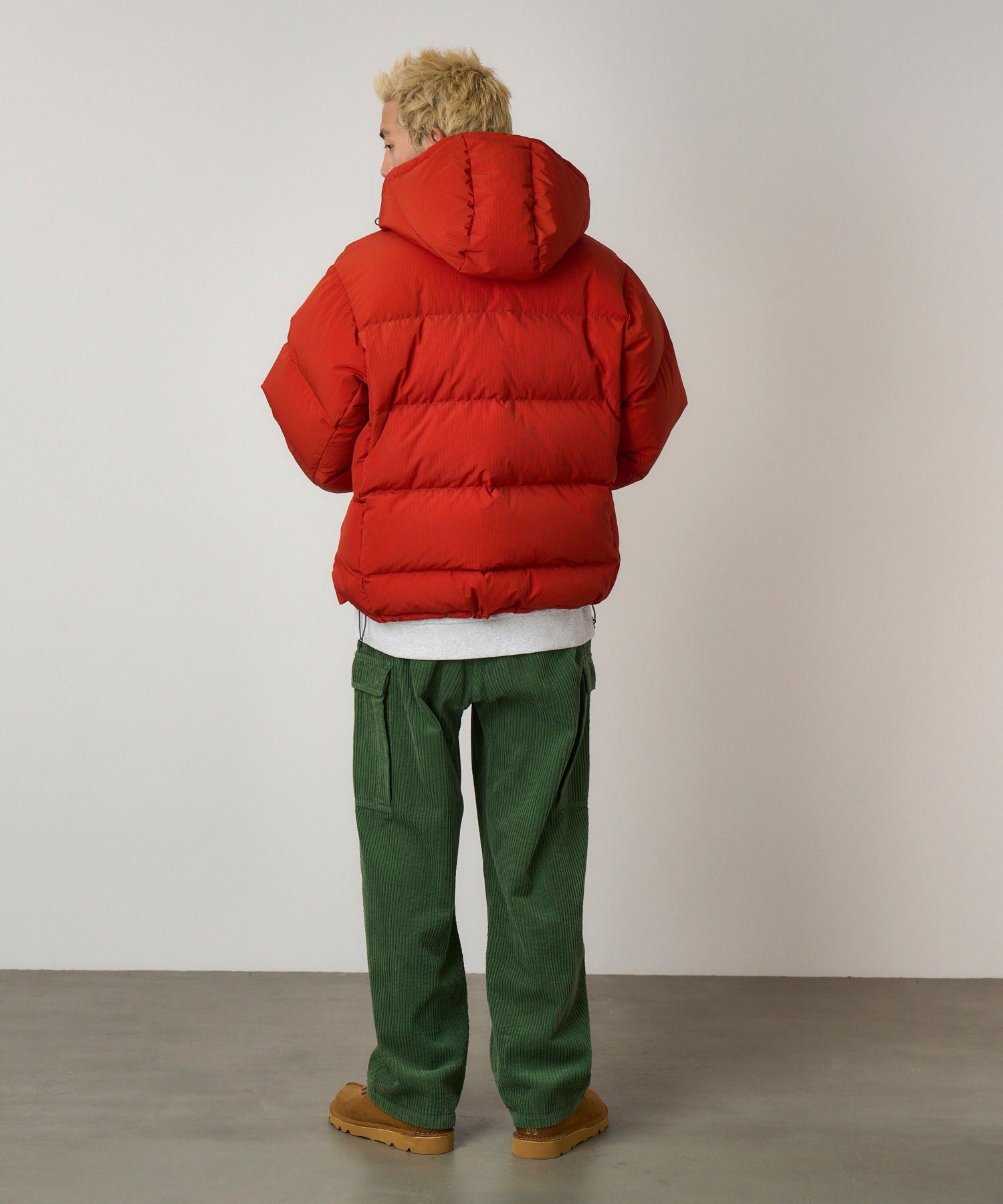 Back view of model wearing Brockton Big Corduroy Pant in Pine Green with wide-wale corduroy fabric, cargo pockets and relaxed fit silhouette
