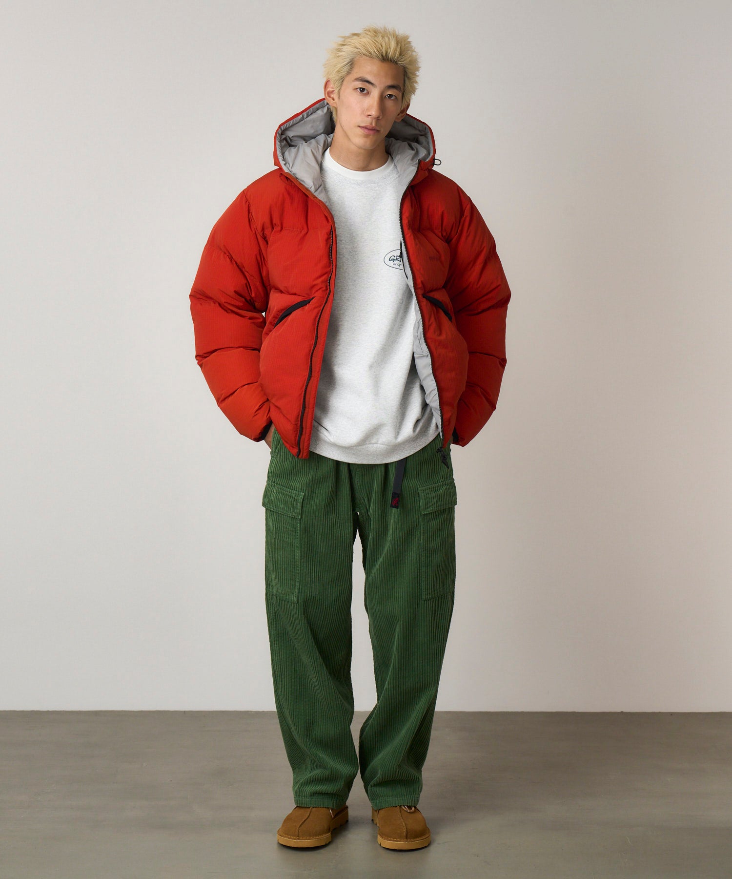 Front view of model wearing Pine Green corduroy cargo pants with relaxed fit and utility pocket design for everyday style