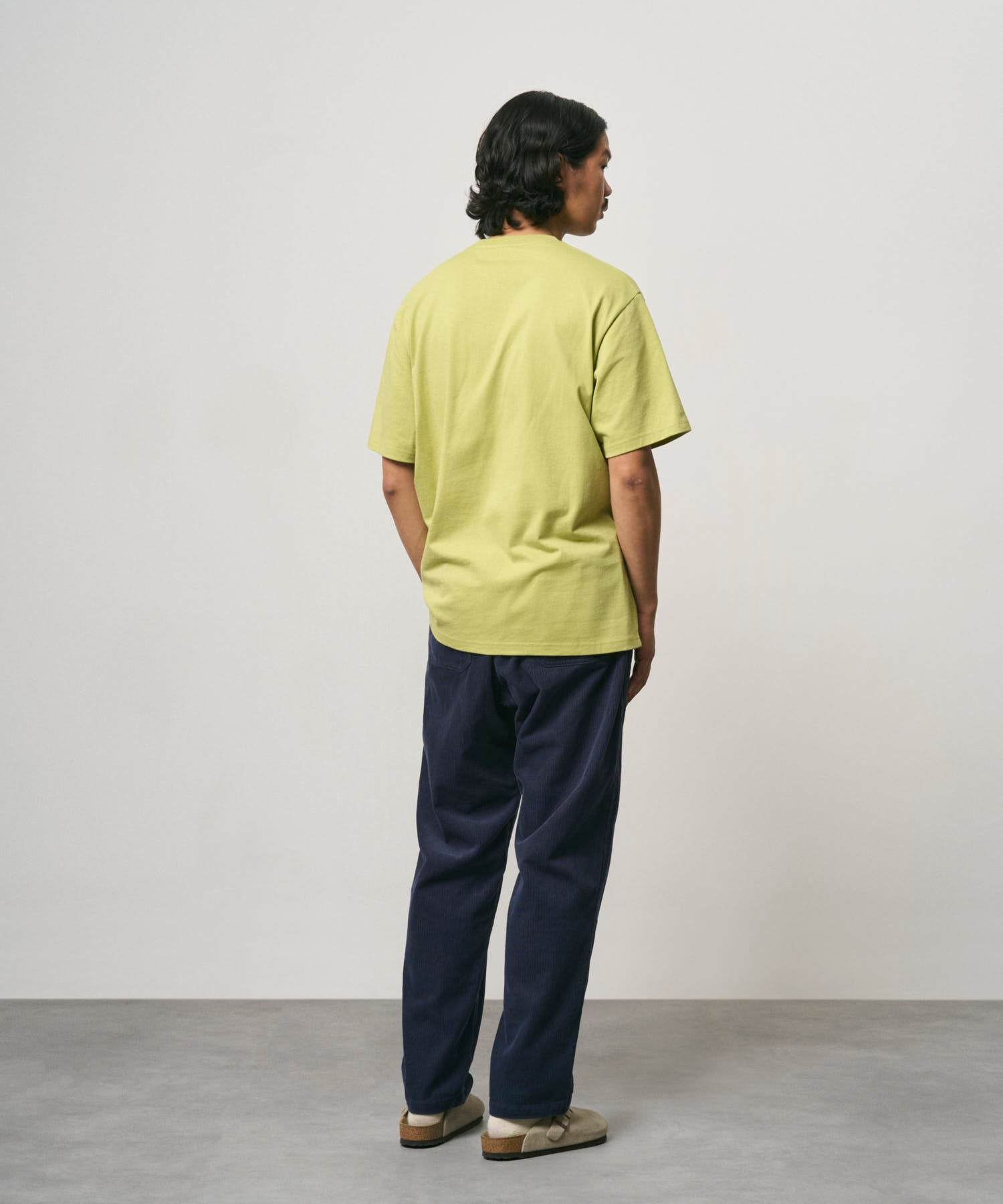Back view of male model wearing Gramicci Ladybug Tee Sweet Pea premium cotton graphic T-shirt