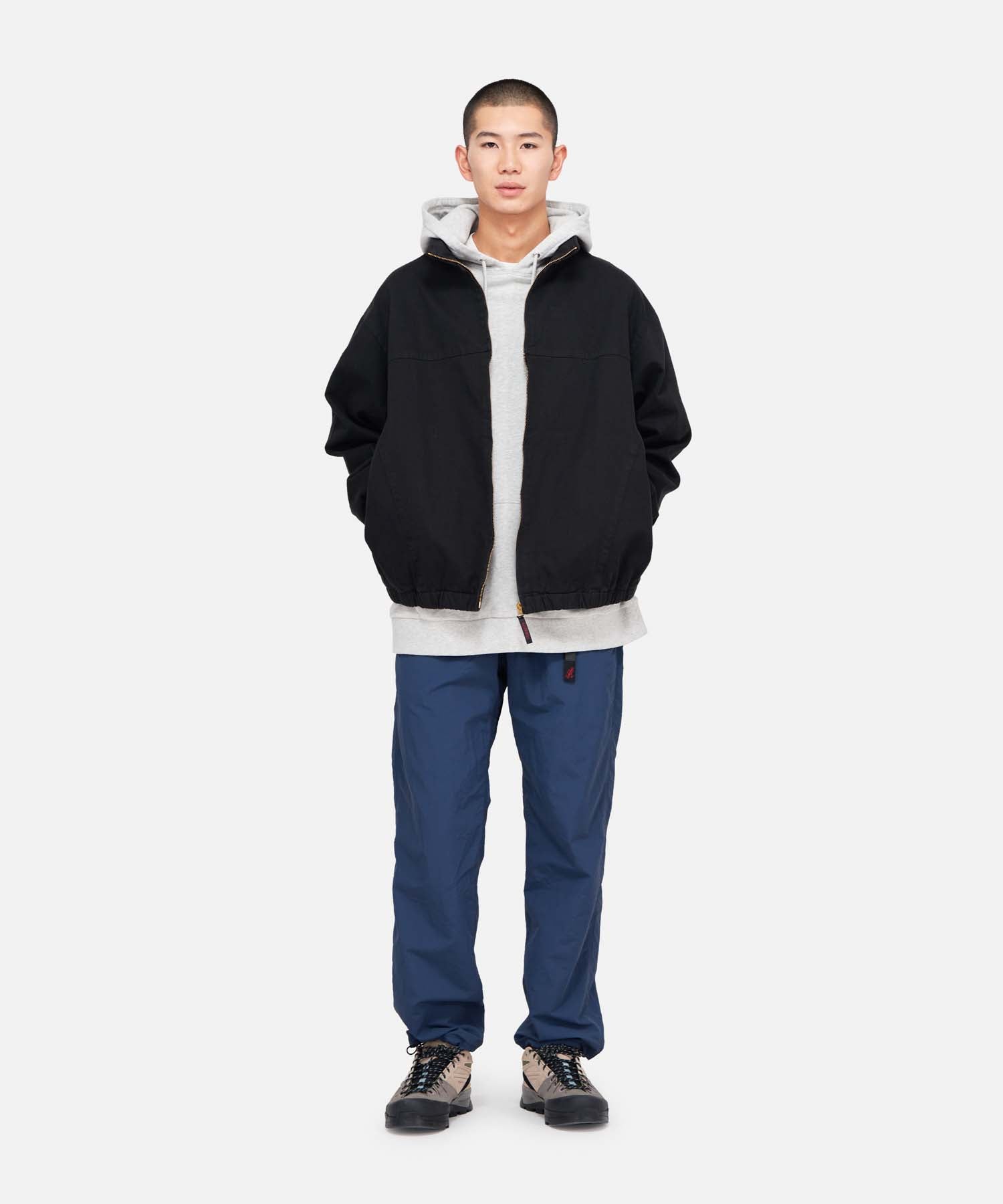 Model wearing Gramicci Twill-Around Jacket Black in eco cotton twill with relaxed fit, stand collar and zip-front design for everyday wear.