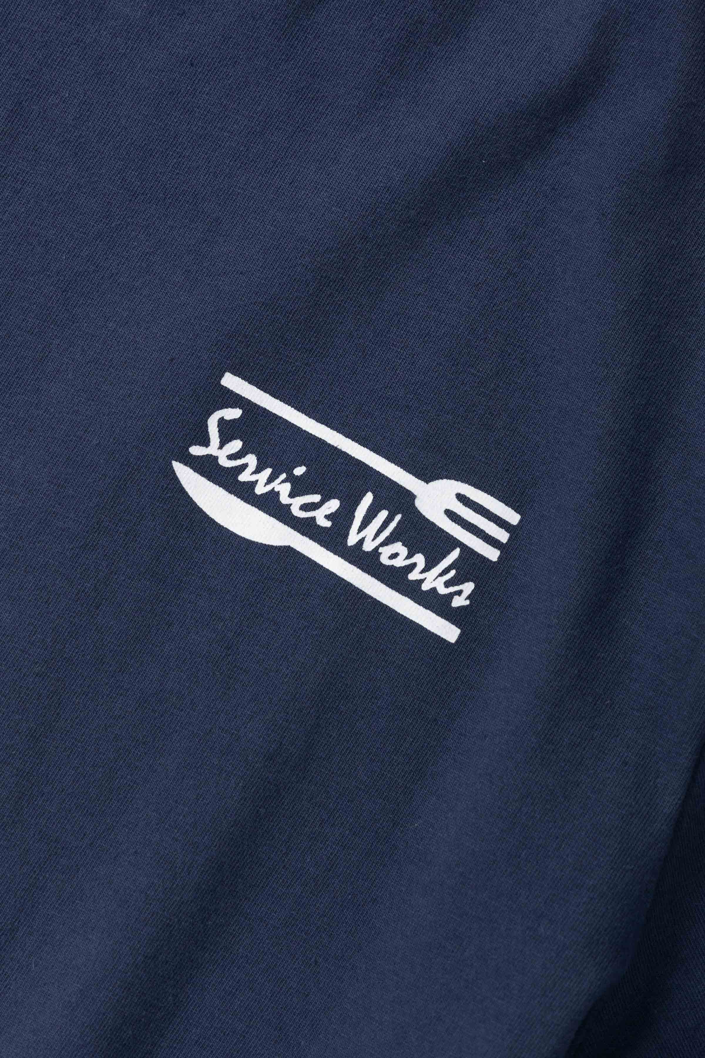Model wearing navy Milos Tee featuring organic cotton fabric, clean fit and versatile everyday casual streetwear styling