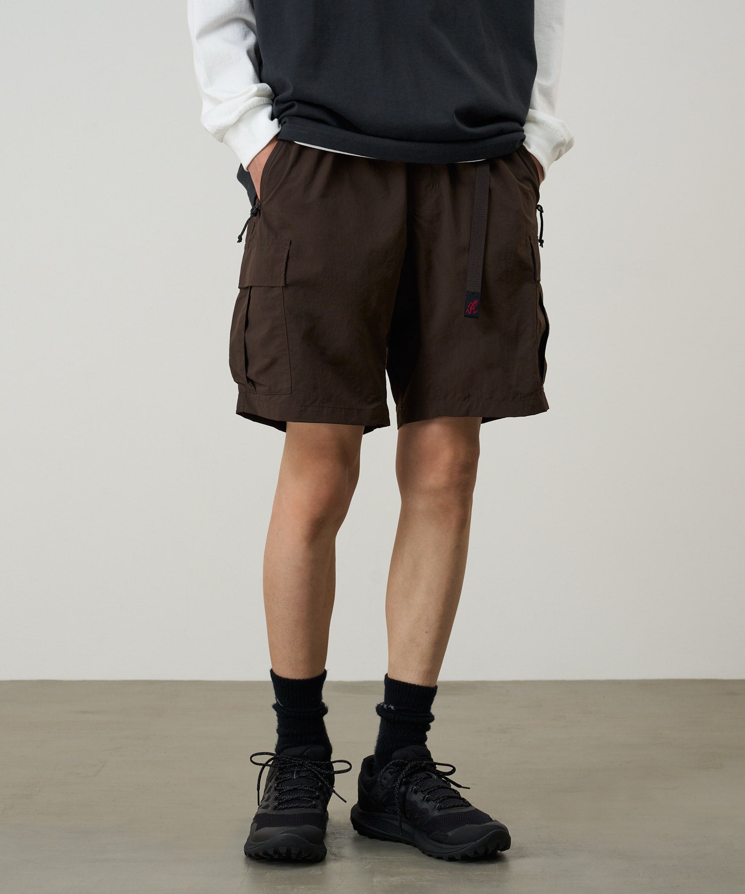 Side view of model wearing Nylon Explorer Cargo Shorts in Chocolate