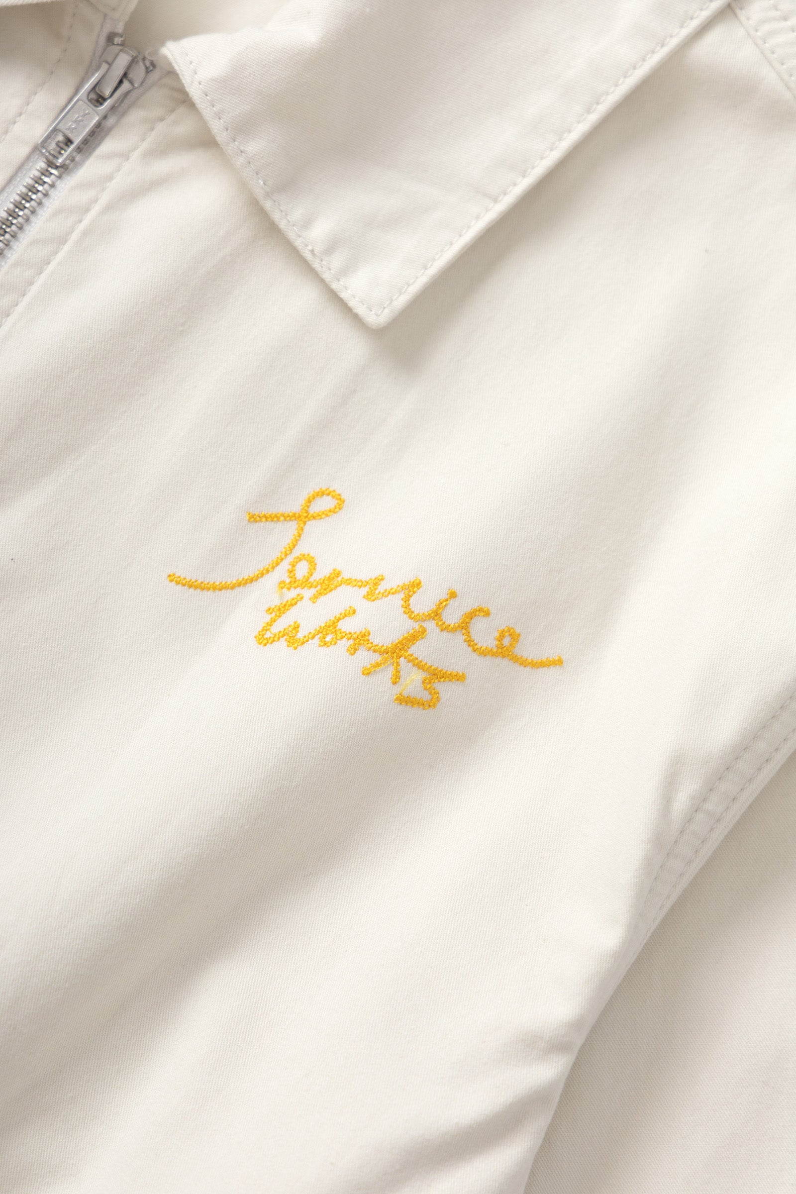 Front detail of off white twill work jacket for men showing structured design and durable fabric