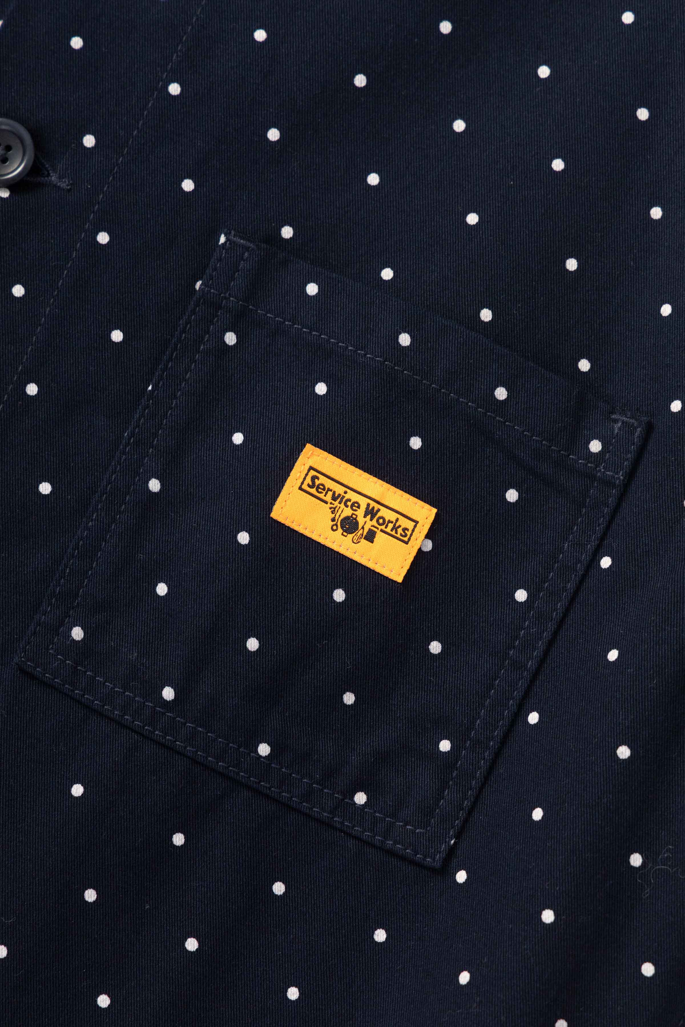 Detail view of navy polka dot chore shirt highlighting organic cotton drill fabric, button-up front and durable workwear stitching