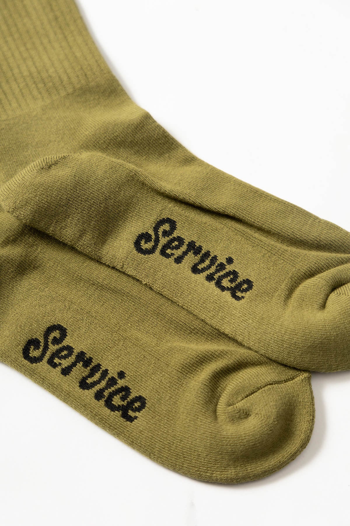 Olive Salt + Pepper crew socks by Service Works with signature graphic, side view on white background