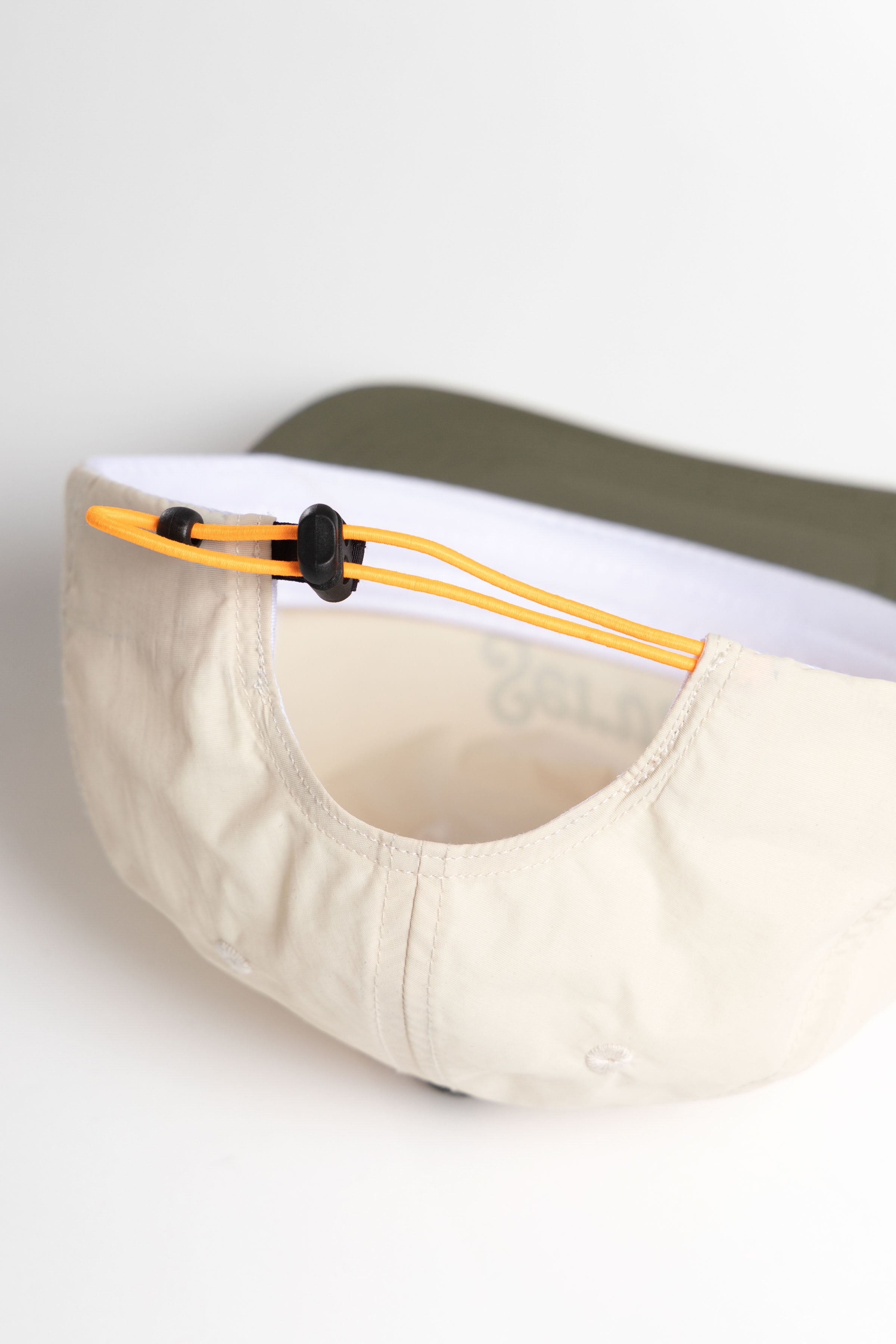 Model wearing off-white and olive Script Surf Cap shown from side angle featuring cotton fabric, curved brim and relaxed surf-inspired fit