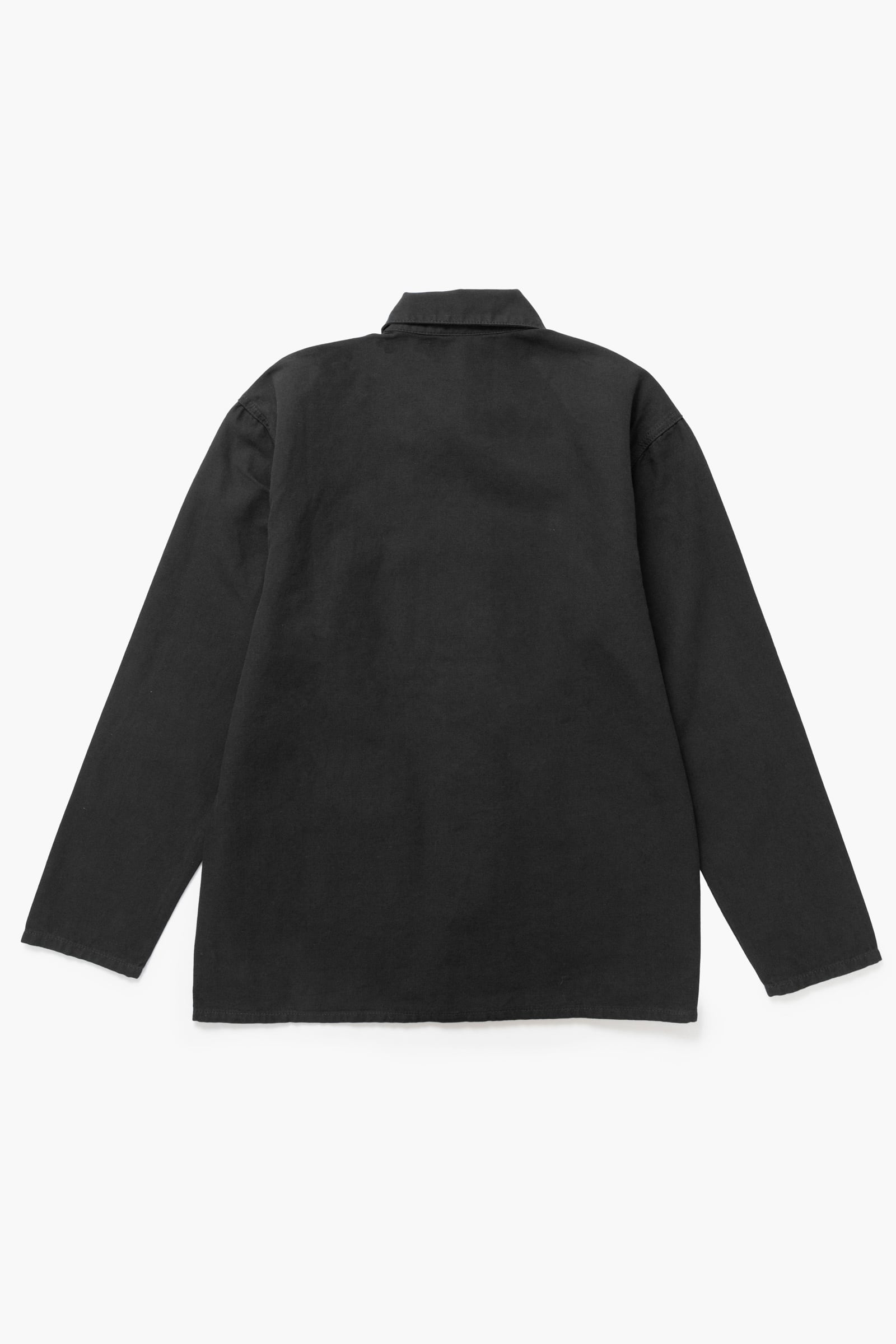 Close-up of the Service Works Canvas Chore Shirt in Black highlighting woven logo label and canvas fabric texture.