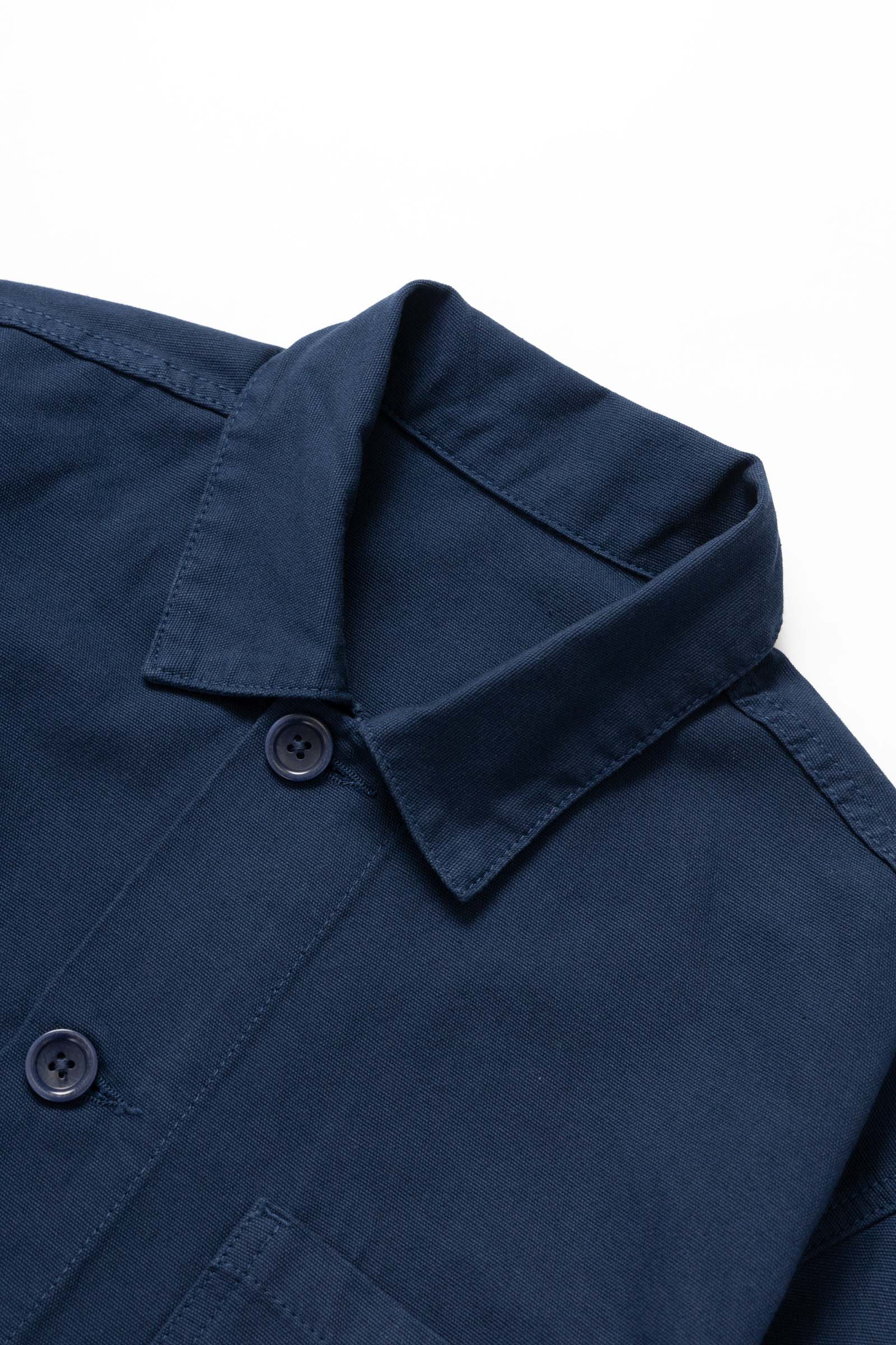 Close-up detail of the Service Works Canvas Chore Shirt in Navy showing durable canvas texture and woven logo label.