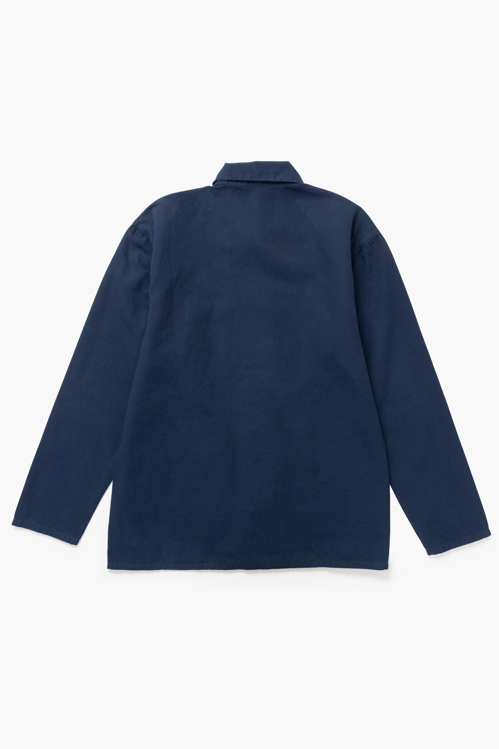 Close-up of the Service Works Canvas Chore Shirt in Navy showing the woven logo label and canvas fabric texture detail.