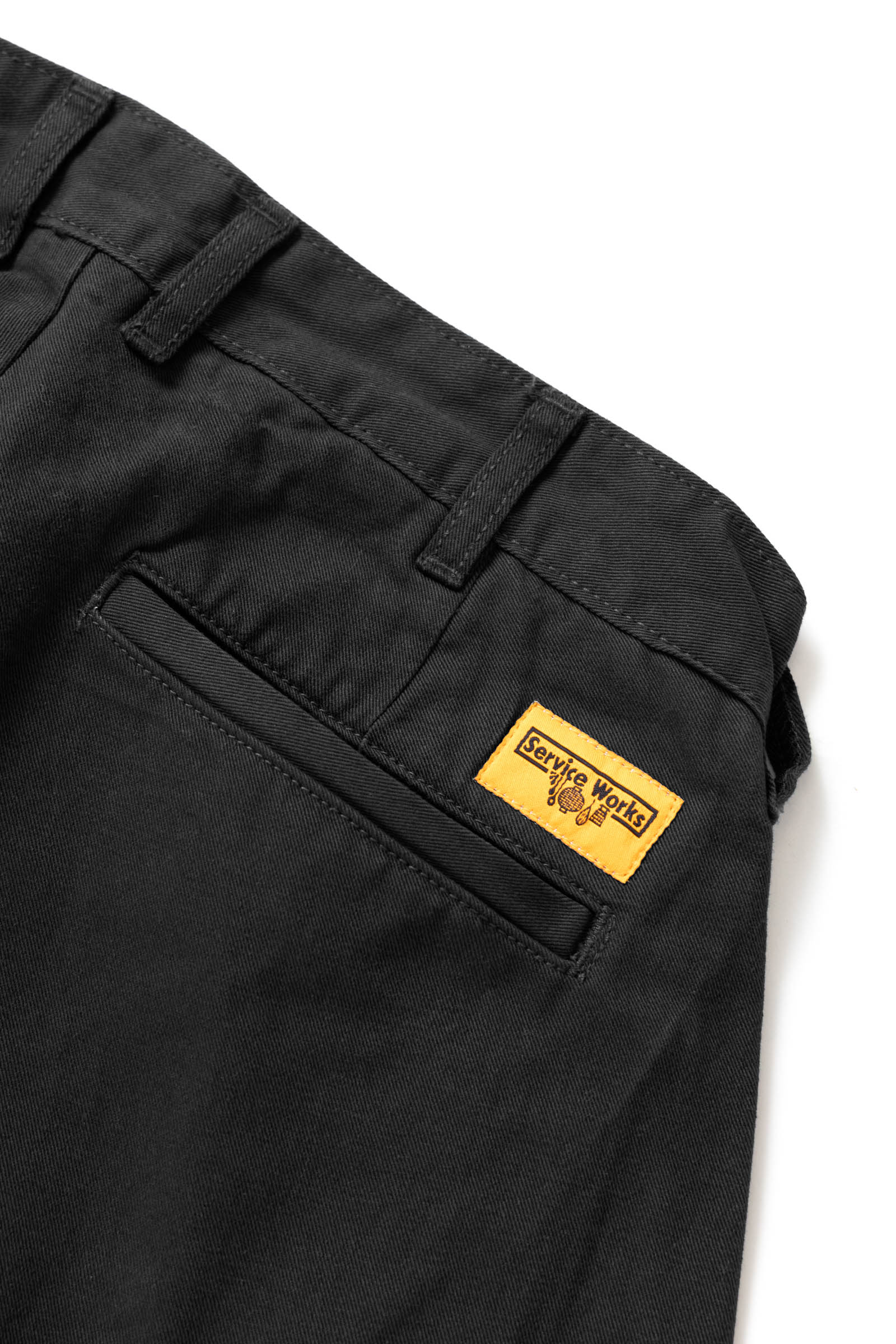 Close-up of the Service Works Drill Part Timer Pant in Black showing belt loops and waistband construction for adjustable fit.