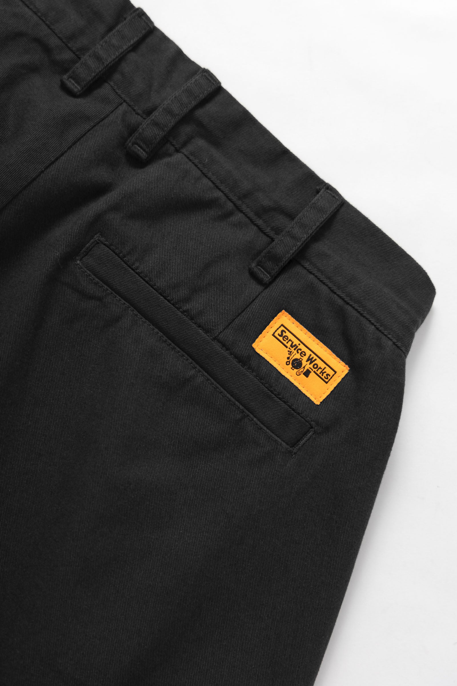 Close-up of the Service Works Drill Part Timer Short in Black showing belt loops, pleats and functional pocket design.