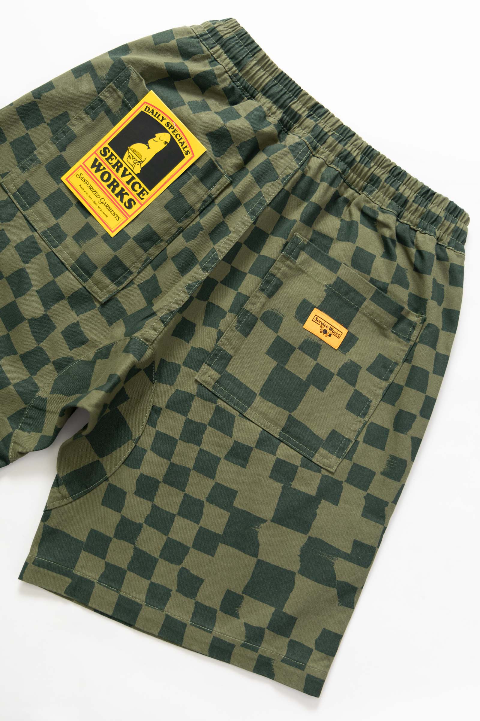 Close-up detail of the Service Works Printed Chef Short in Olive Checker showing check pattern fabric and reinforced stitching.