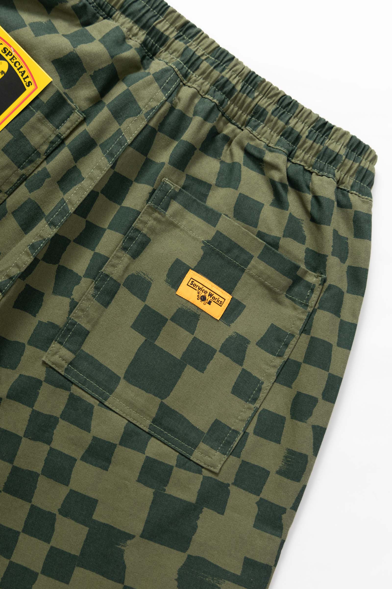 Close-up of the Service Works Printed Chef Short in Olive Checker highlighting fatigue pocket design and reinforced construction.