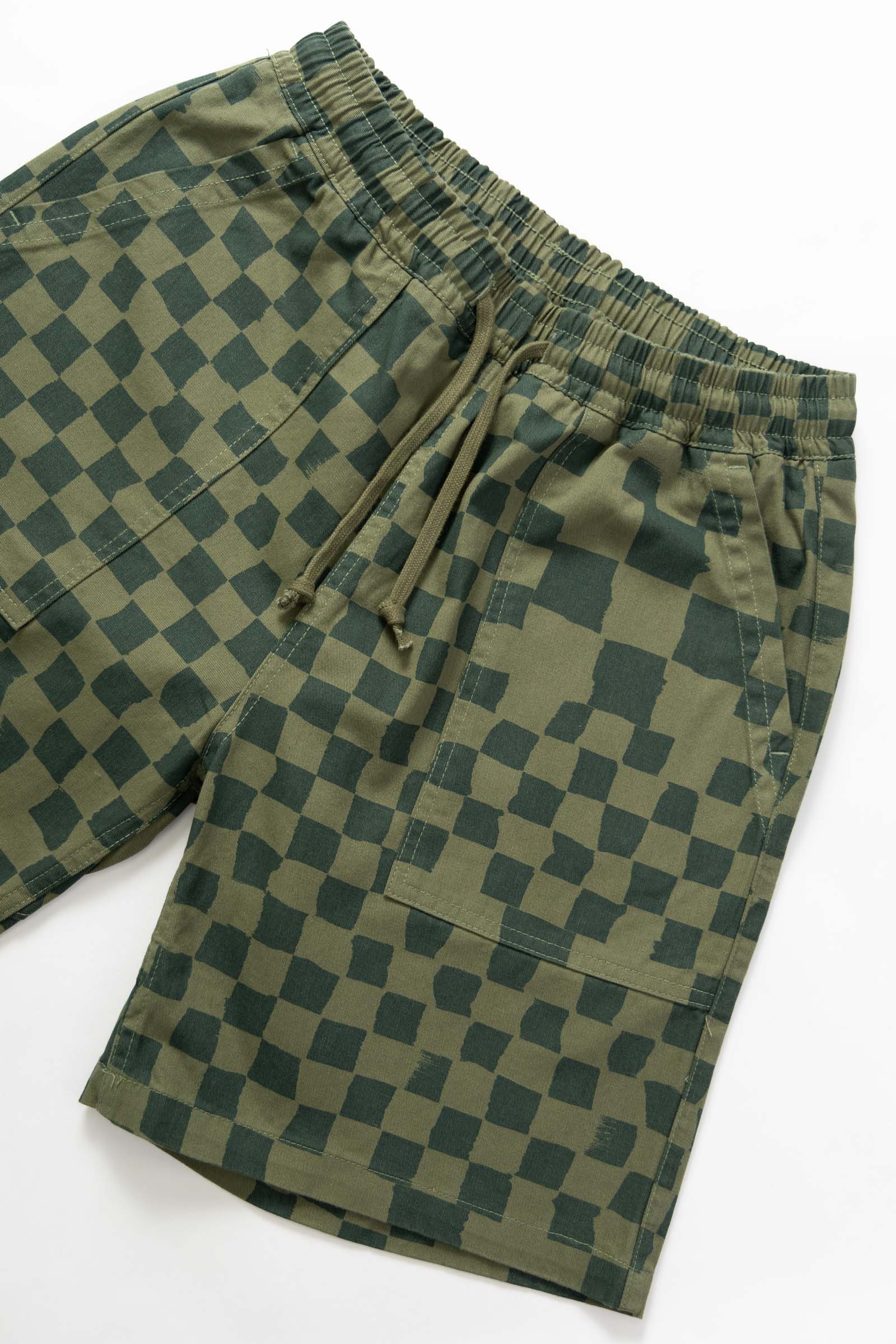 Side view of the Service Works Printed Chef Short in Olive Checker with relaxed straight fit and elastic waistband.