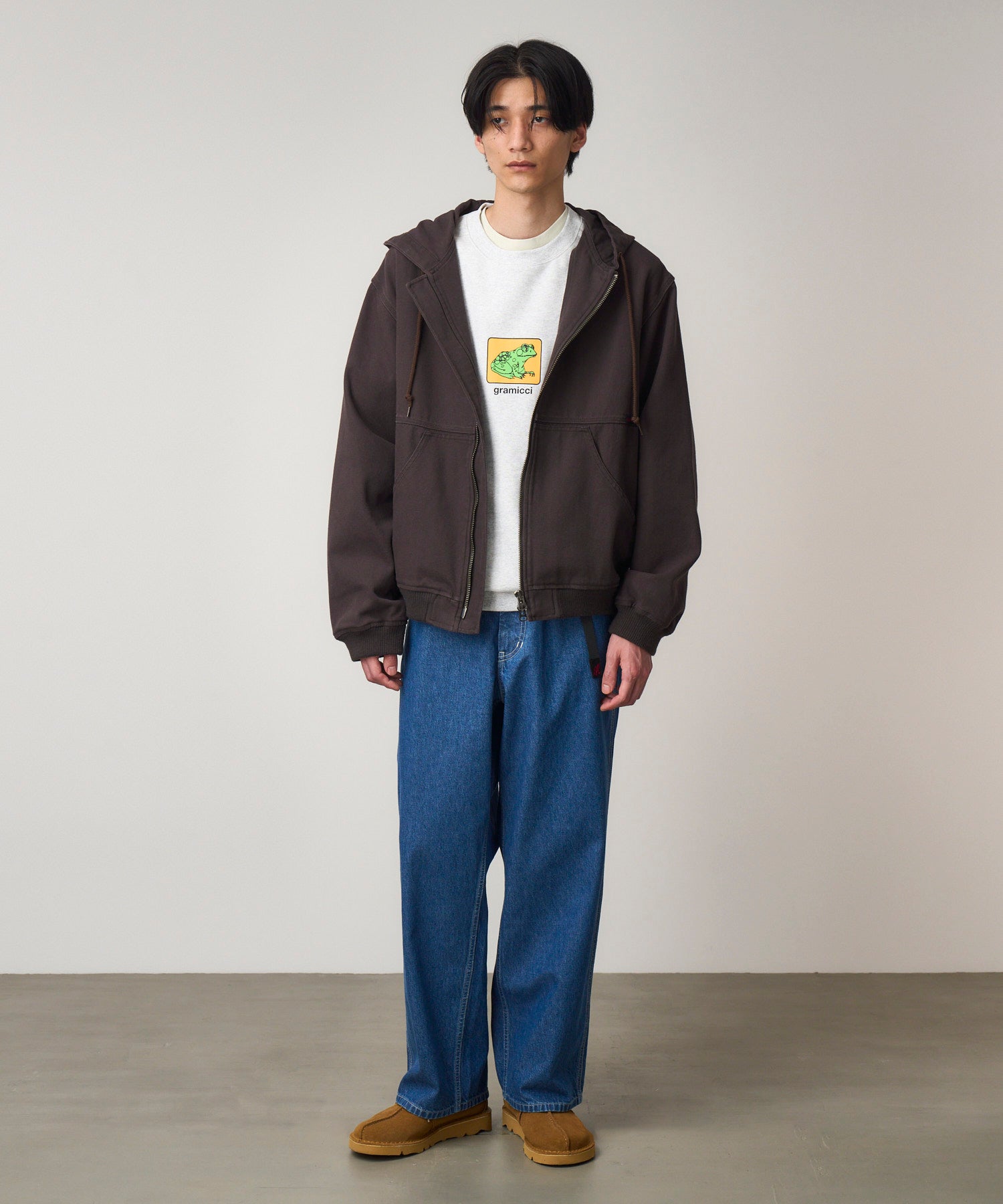 Front view of model wearing light wash relaxed fit denim jeans with roomy silhouette and eco-cotton fabric