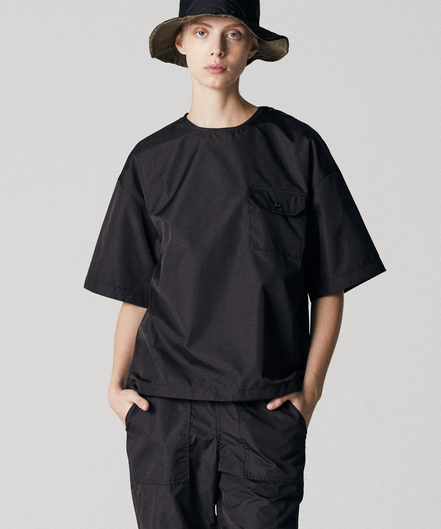 Model wearing Taion Non Down Military Half Sleeve Cut Sew in Black with lightweight fabric and relaxed everyday fit