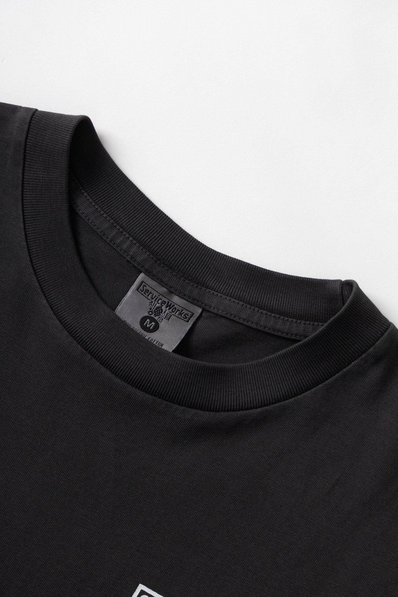 Black pigment dyed trademark tee lifestyle view premium vintage streetwear oversized fit washed cotton outfit