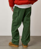 Lifestyle view of Pine Green corduroy cargo pants worn in casual streetwear style with relaxed silhouette and utility pocket design
