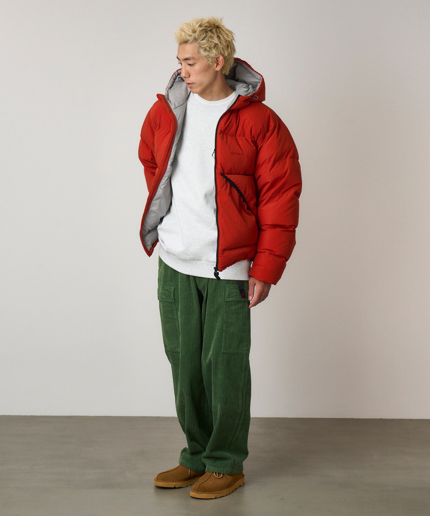 Side view of model wearing Brockton Big Corduroy Pant in Pine Green with wide-wale corduroy fabric, cargo pockets and relaxed fit silhouette