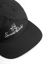 Front view of model wearing black Chefs Kiss Cap with nylon construction, curved peak brim and relaxed low profile streetwear fit