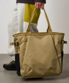 Model carrying Bronze Olive Climbing Tote bag made from recycled CORDURA nylon, designed for travel, work and everyday carry