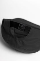 Model wearing black Chefs Kiss Cap shown from back, featuring unstructured nylon construction, curved brim and adjustable strap for secure fit