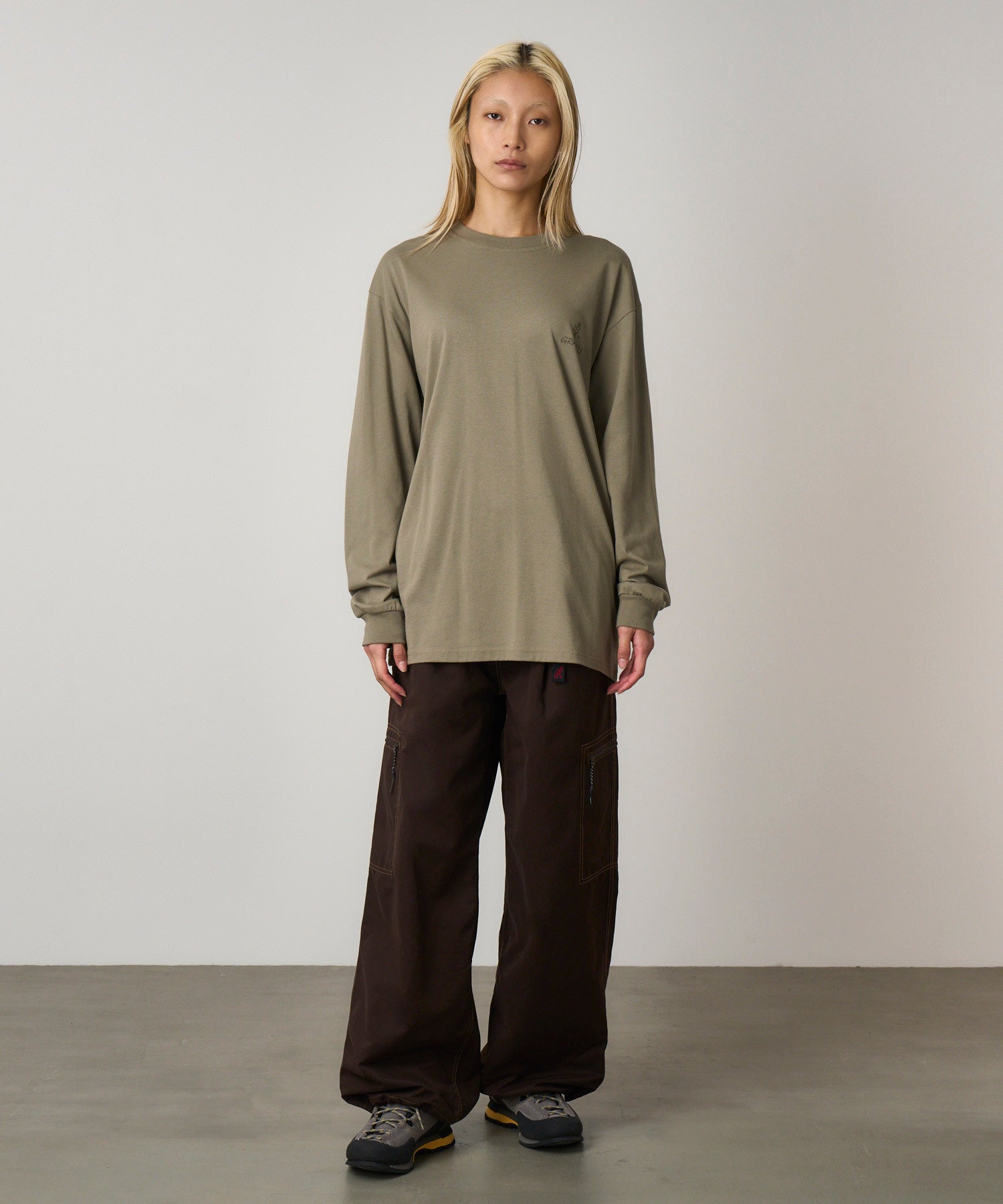 Front view of model wearing khaki long sleeve t-shirt with regular fit and chest logo, styled for everyday comfort