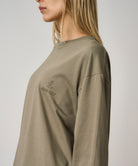 Model wearing khaki long sleeve t-shirt with regular fit and chest logo, styled for casual everyday comfort and streetwear