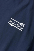 Model wearing navy Milos Tee featuring organic cotton fabric, clean fit and versatile everyday casual streetwear styling