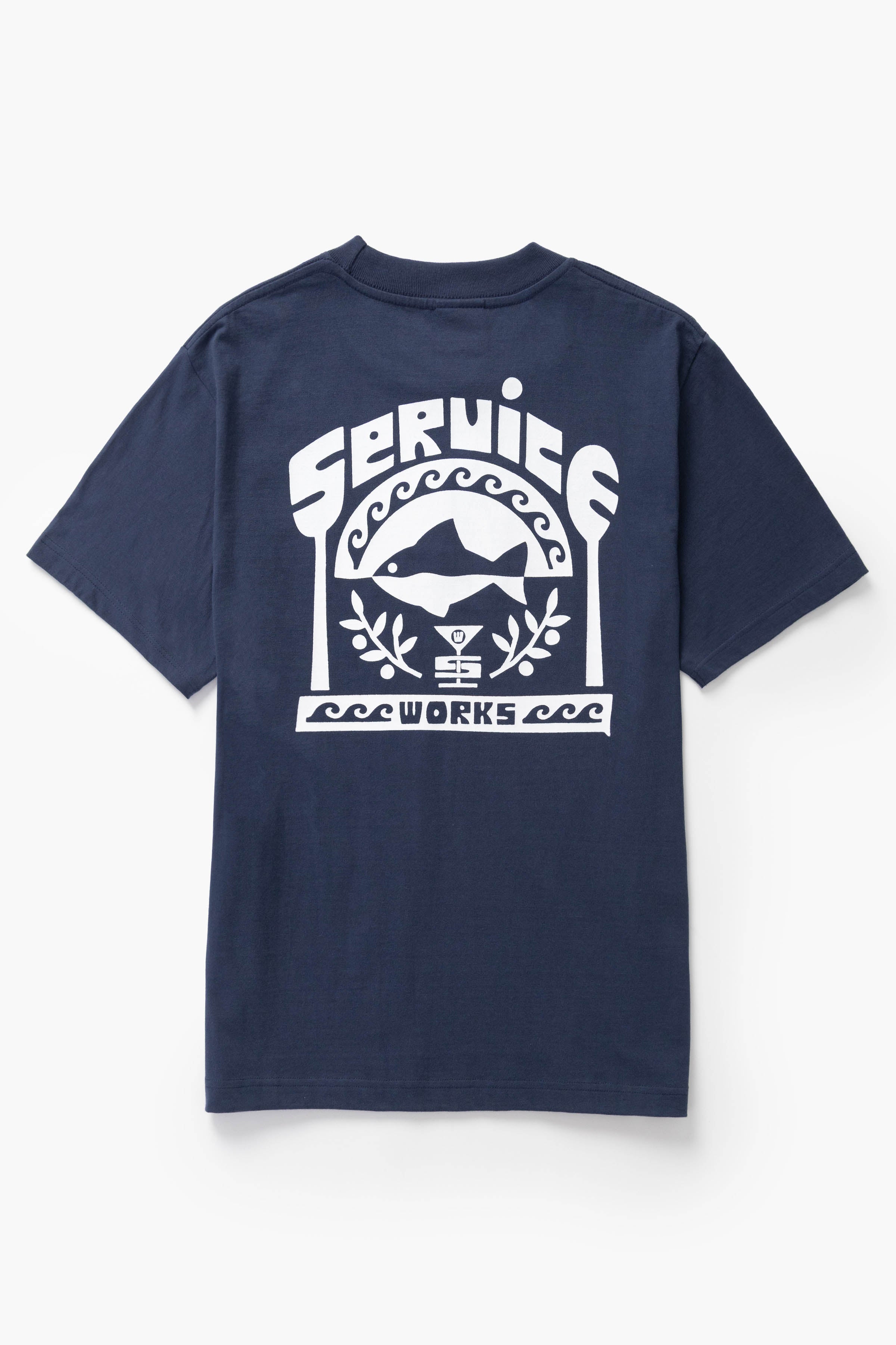Model wearing navy Milos Tee shown from side angle featuring organic cotton fabric, clean silhouette and everyday streetwear styling