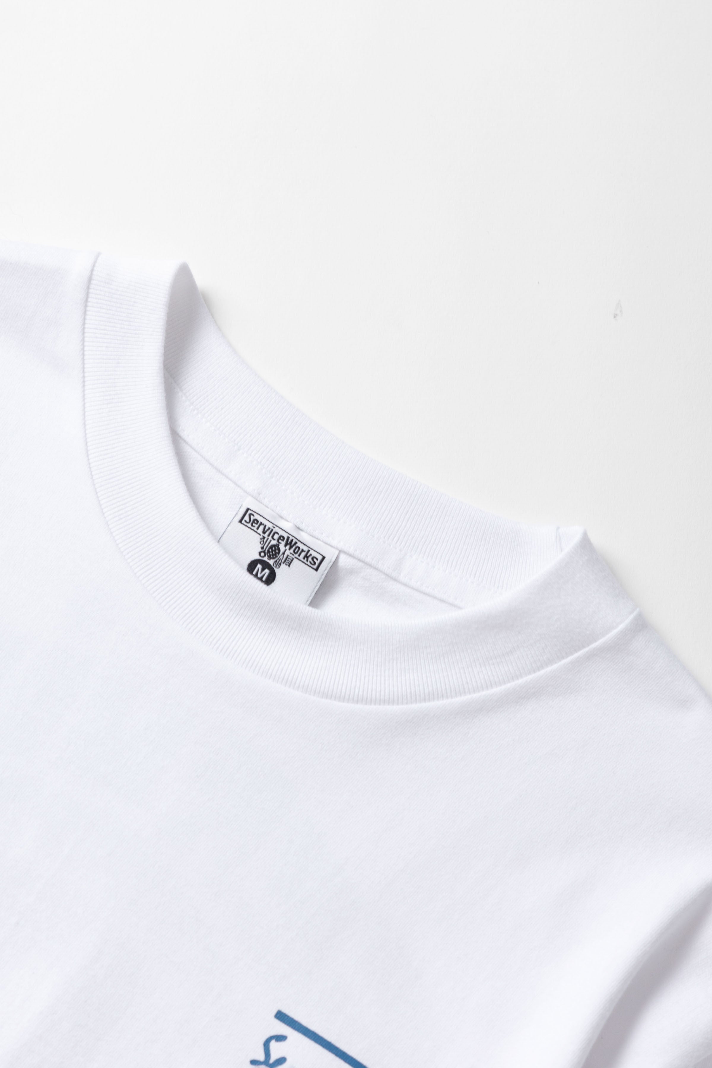 Detail view of white Milos Tee highlighting organic cotton fabric, midweight texture and high-quality everyday streetwear construction
