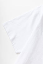 Model styled in white Milos Tee with premium organic cotton fabric, standard fit and clean casual streetwear look for everyday wear