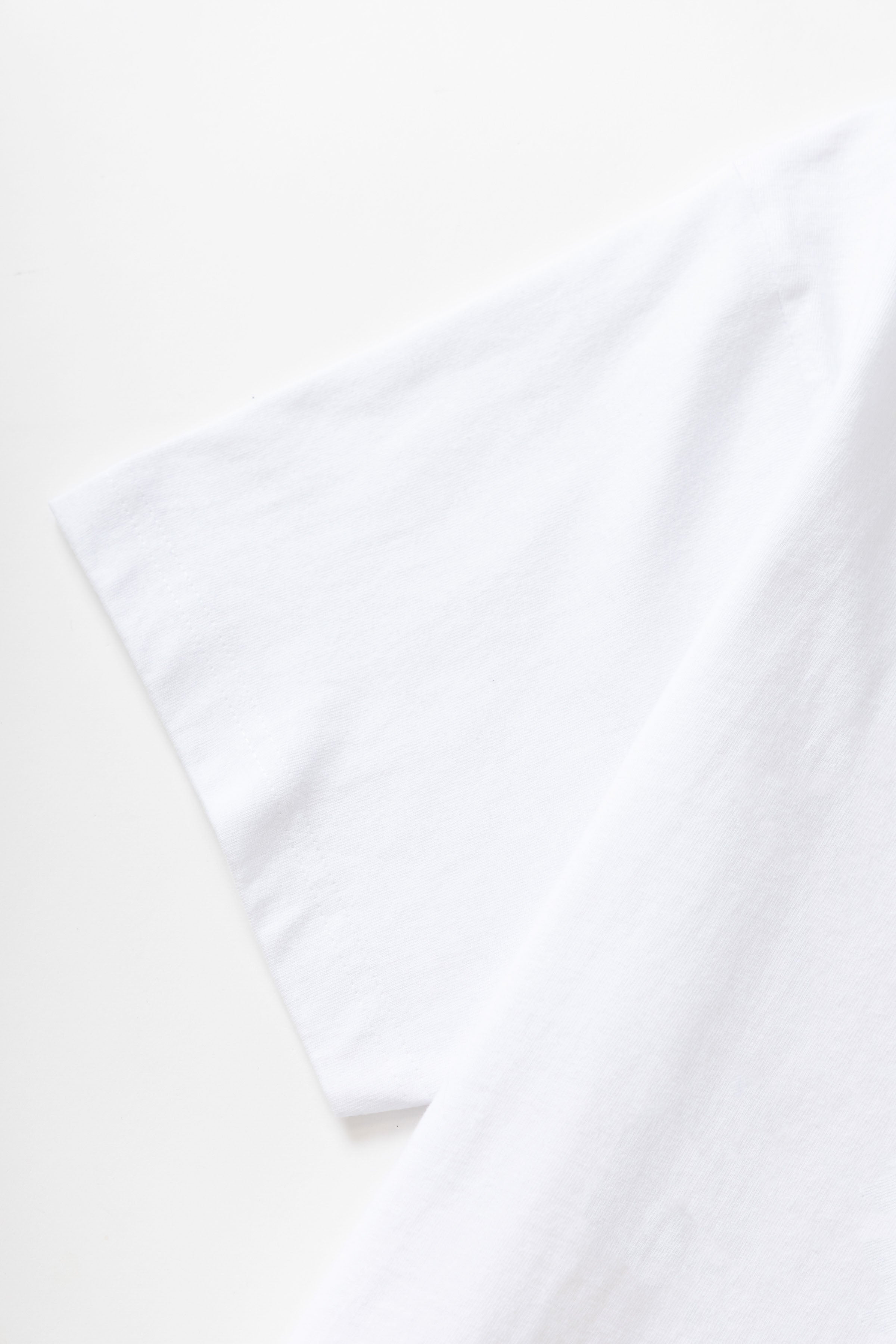 Model styled in white Milos Tee with premium organic cotton fabric, standard fit and clean casual streetwear look for everyday wear
