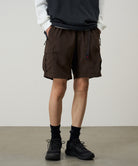Side view of model wearing Nylon Explorer Cargo Shorts in Chocolate