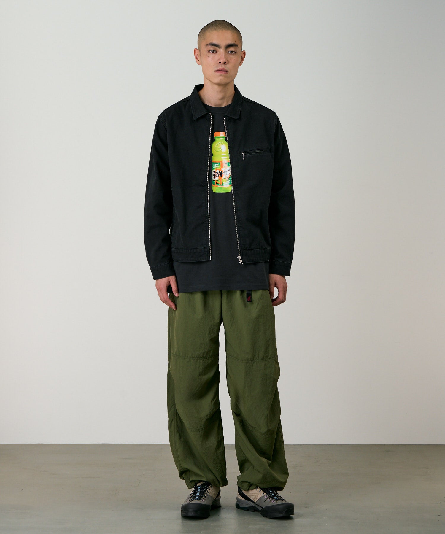 Side view of model wearing olive nylon paneled trek pants with wide-leg relaxed fit and lightweight durable fabric for everyday wear