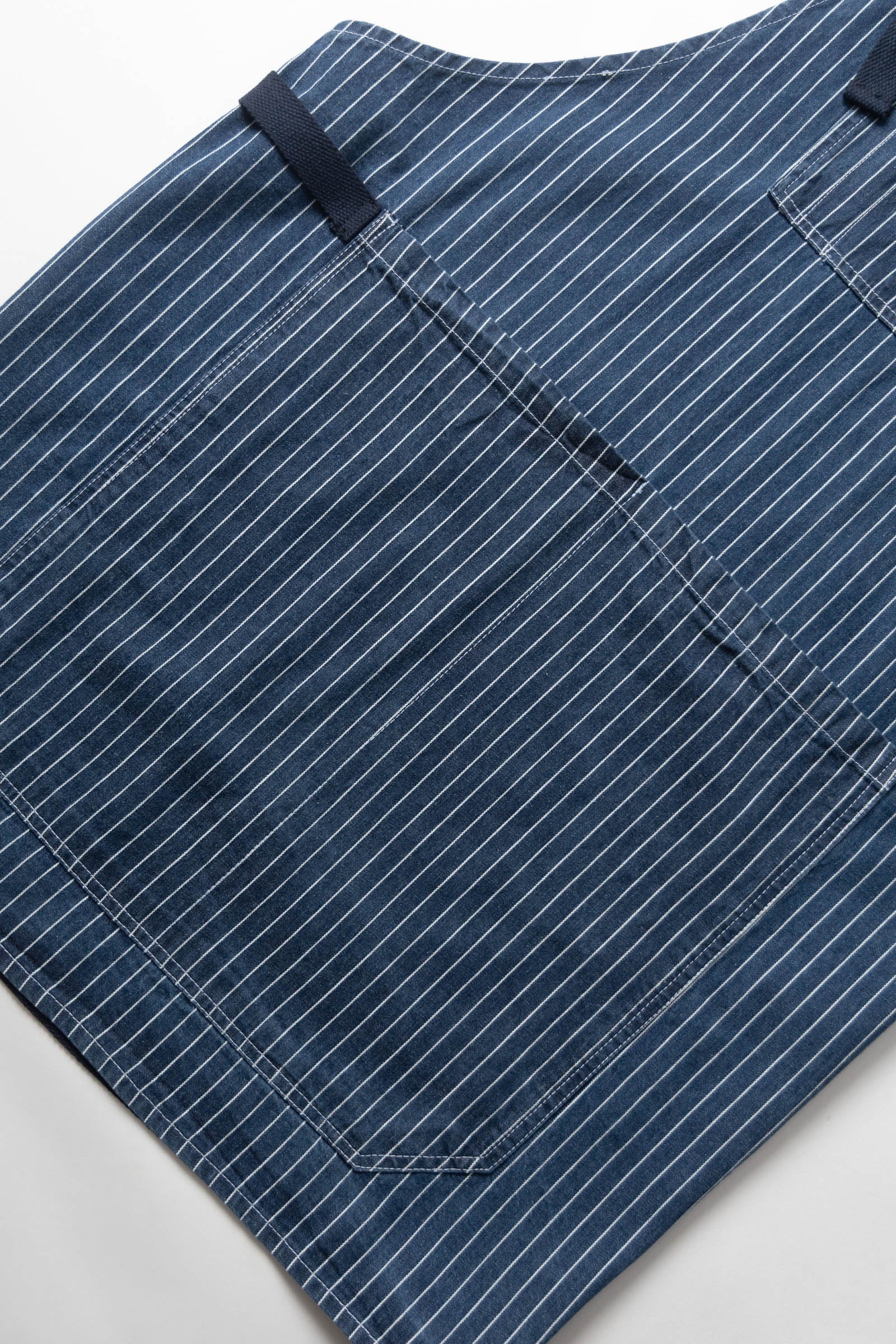 Indigo pinstripe denim apron side view durable premium workwear for cooking barista and workshop