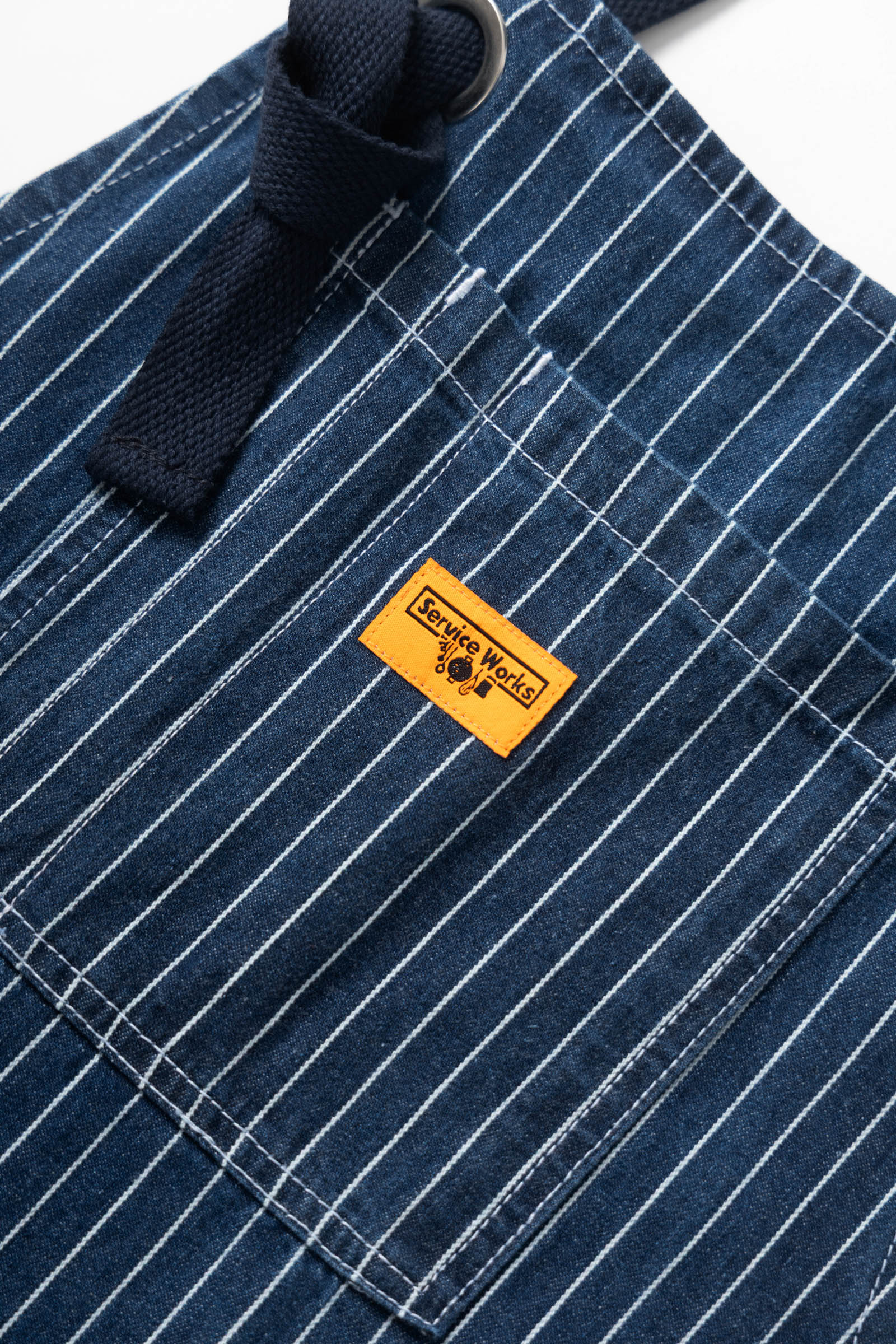 Indigo pinstripe denim apron lifestyle view premium workwear for cooking barista and workshop use