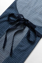 Indigo pinstripe denim apron worn lifestyle view premium workwear cooking barista workshop outfit