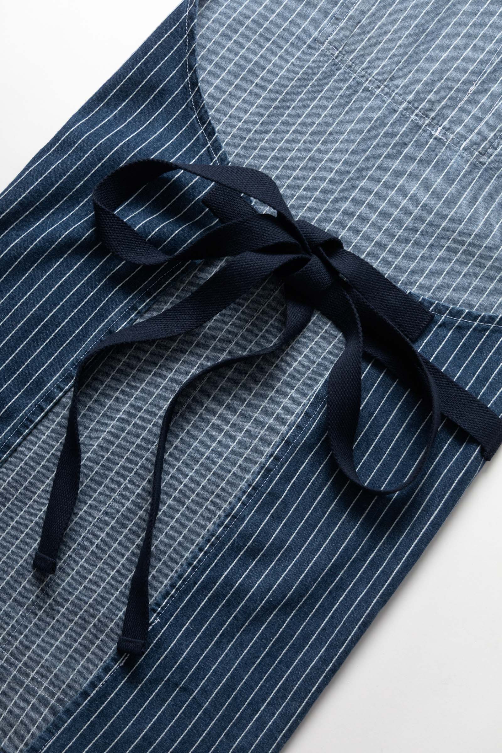 Indigo pinstripe denim apron worn lifestyle view premium workwear cooking barista workshop outfit