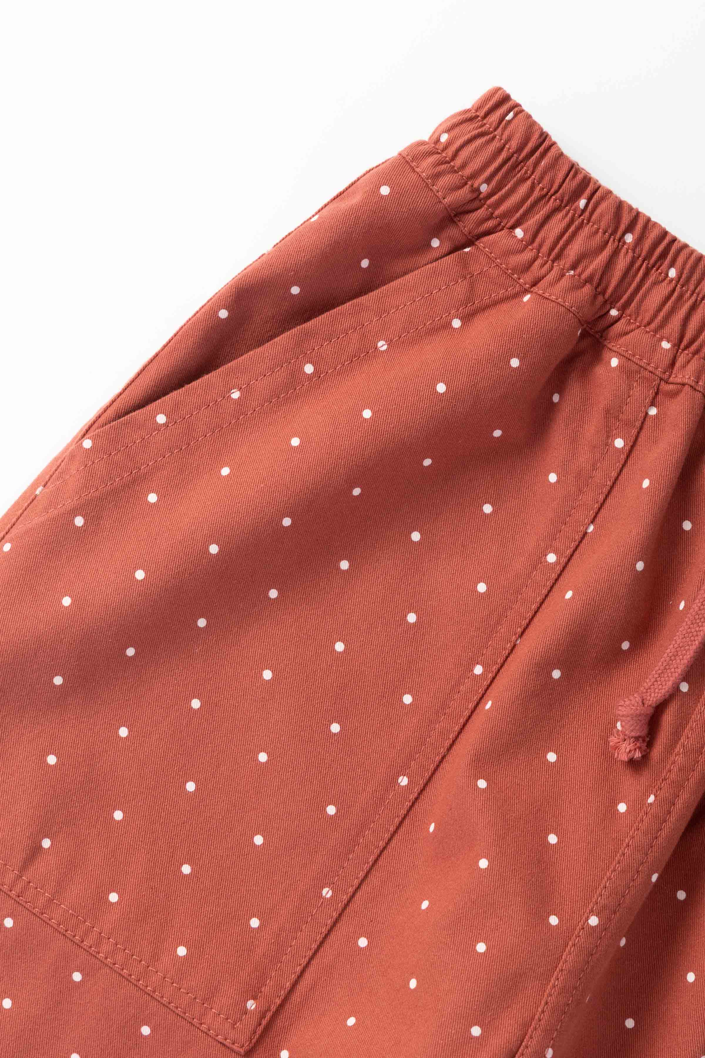 Model wearing clay Polka Dot Chef Pants shown from side angle, featuring organic cotton fabric, relaxed silhouette and functional workwear design