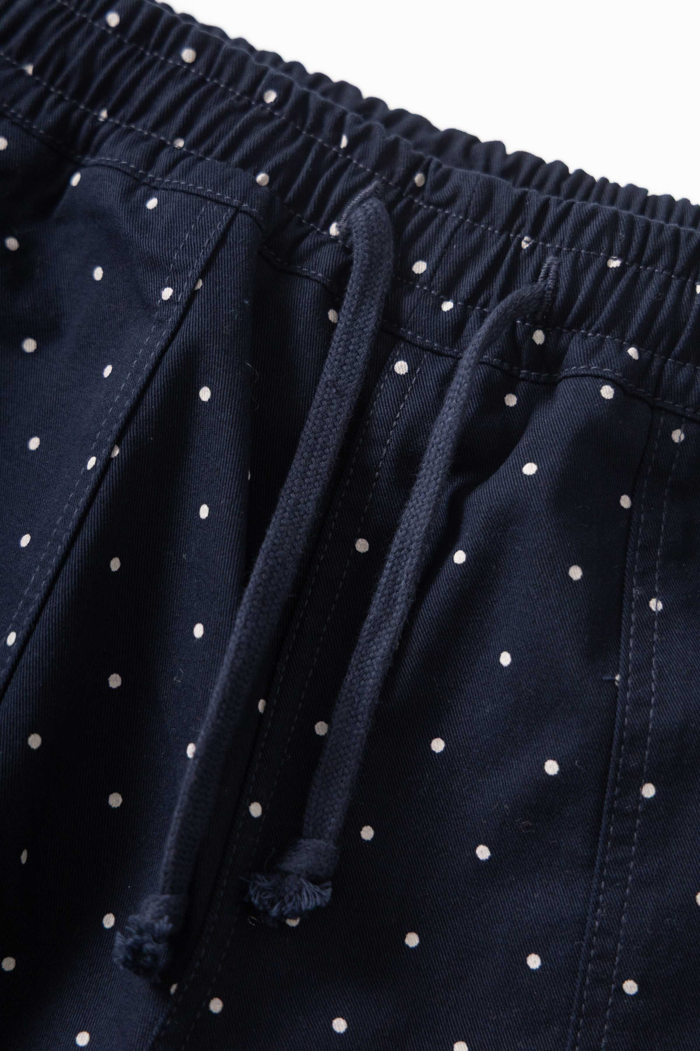 Model wearing navy Polka Dot Chef Pants shown from back featuring organic cotton fabric, relaxed silhouette and durable workwear construction