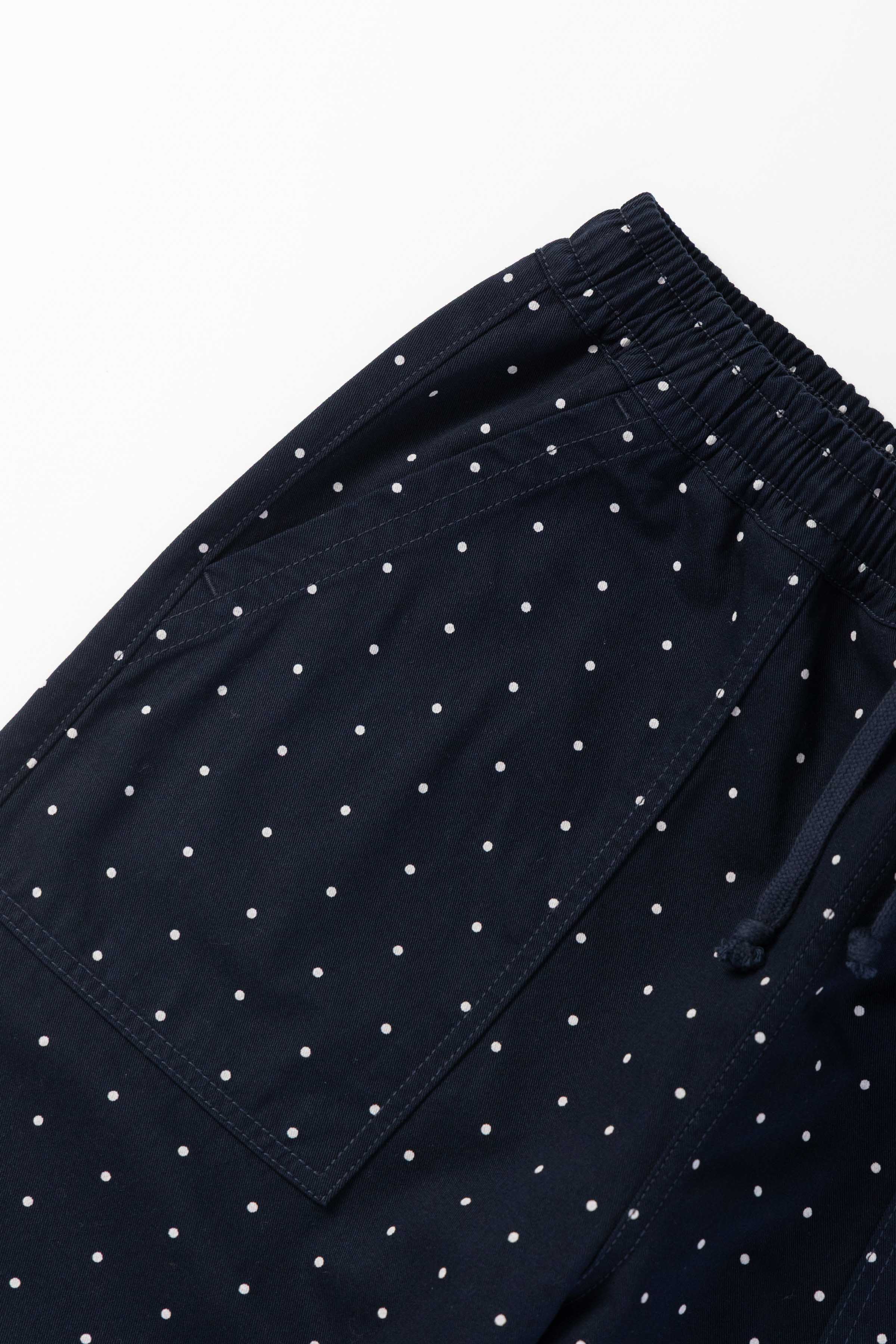 Front view of model wearing navy Polka Dot Chef Pants featuring organic cotton fabric, relaxed silhouette and functional workwear styling