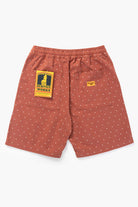 Model wearing clay chef shorts shown from back, featuring organic cotton fabric, relaxed silhouette and functional workwear-inspired design