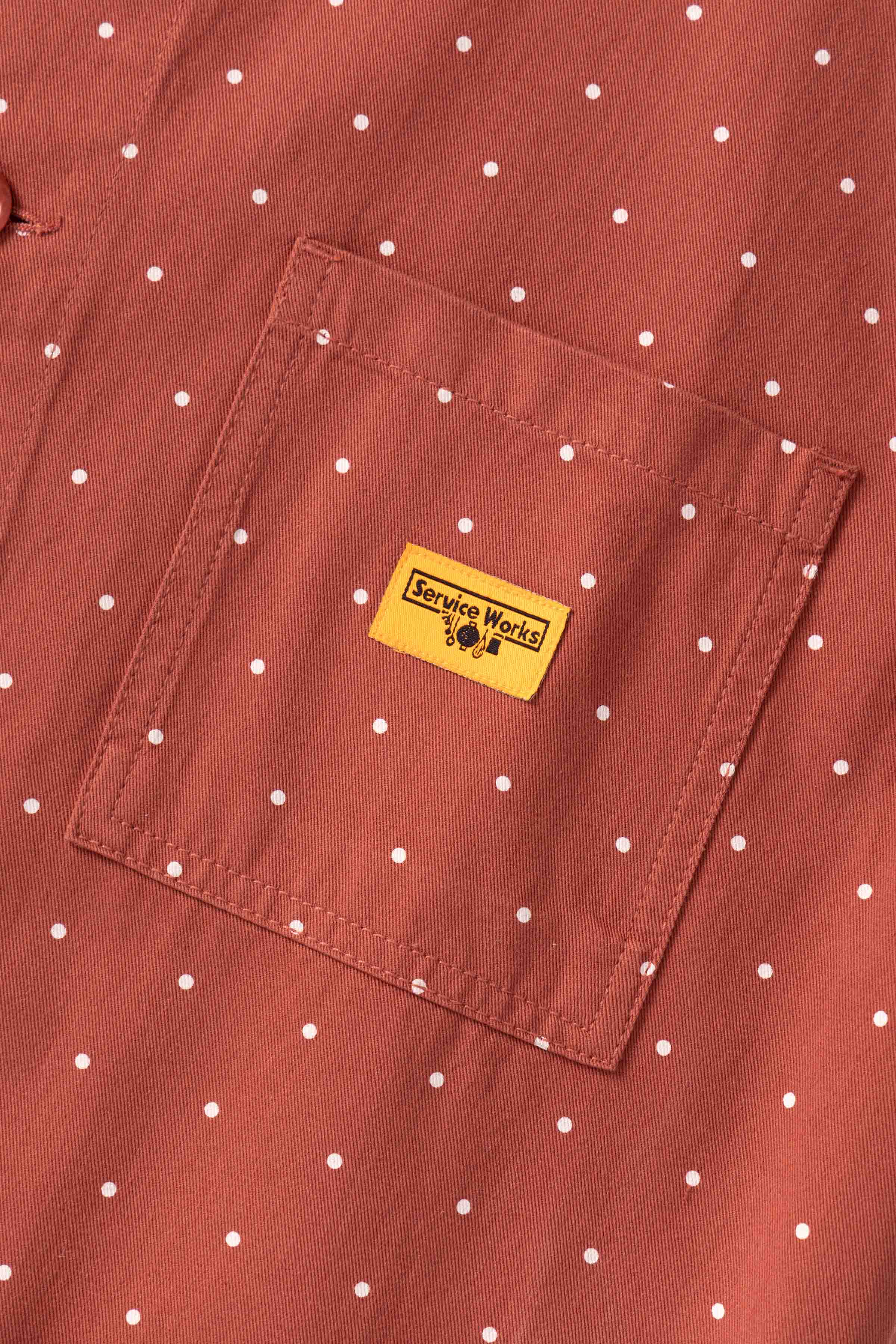Detail view of clay Polka Dot Chore Shirt showing organic cotton fabric, button closure, pocket construction and premium workwear craftsmanship