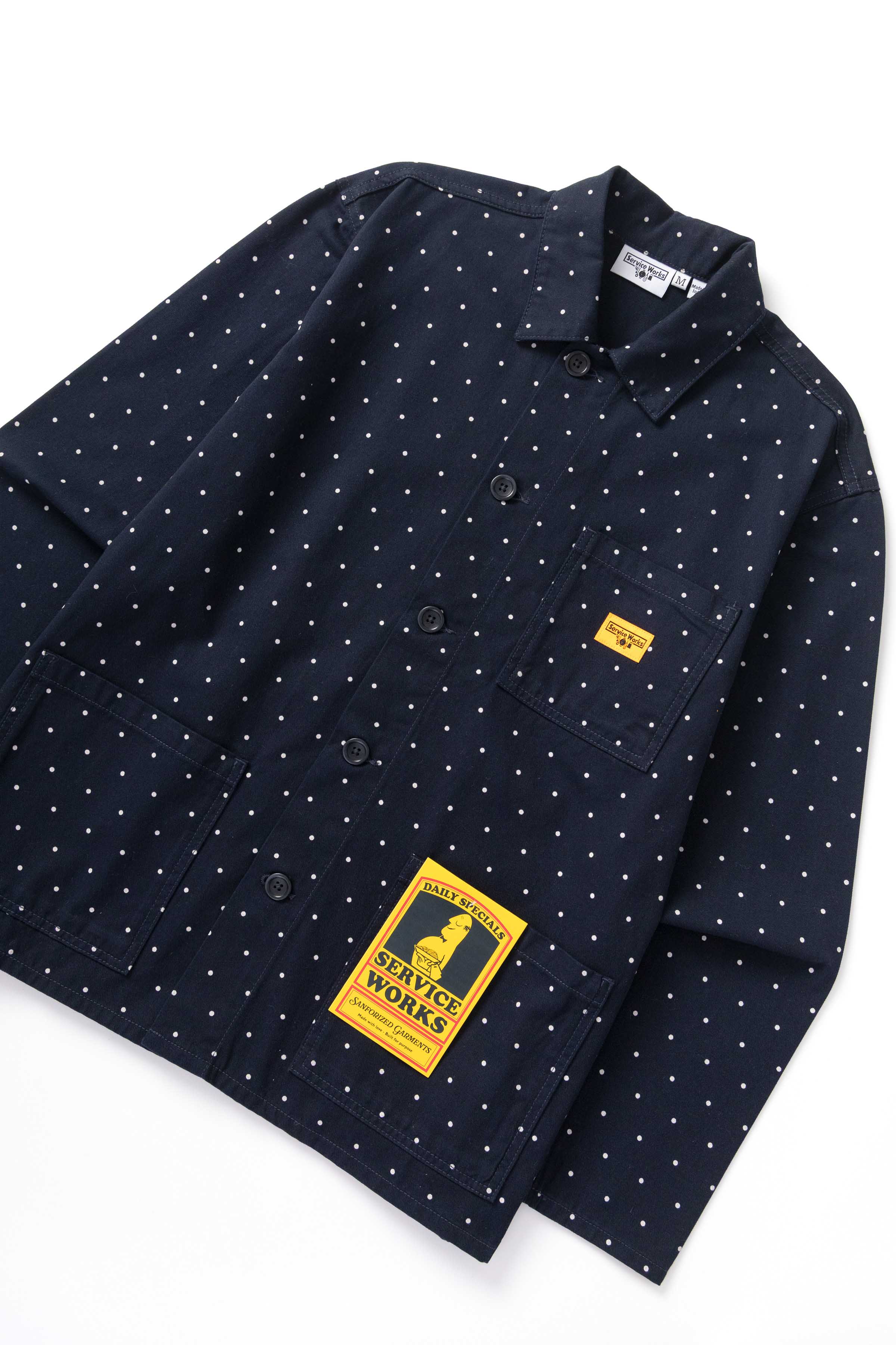 Front view of model wearing navy polka dot chore shirt with relaxed workwear fit, organic cotton fabric and durable utility pocket design