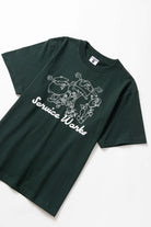 Front view of model wearing forest Pots & Pans Tee featuring organic cotton fabric, clean fit and casual streetwear styling