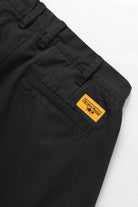 Close-up of the Service Works Drill Part Timer Short in Black showing belt loops, pleats and functional pocket design.